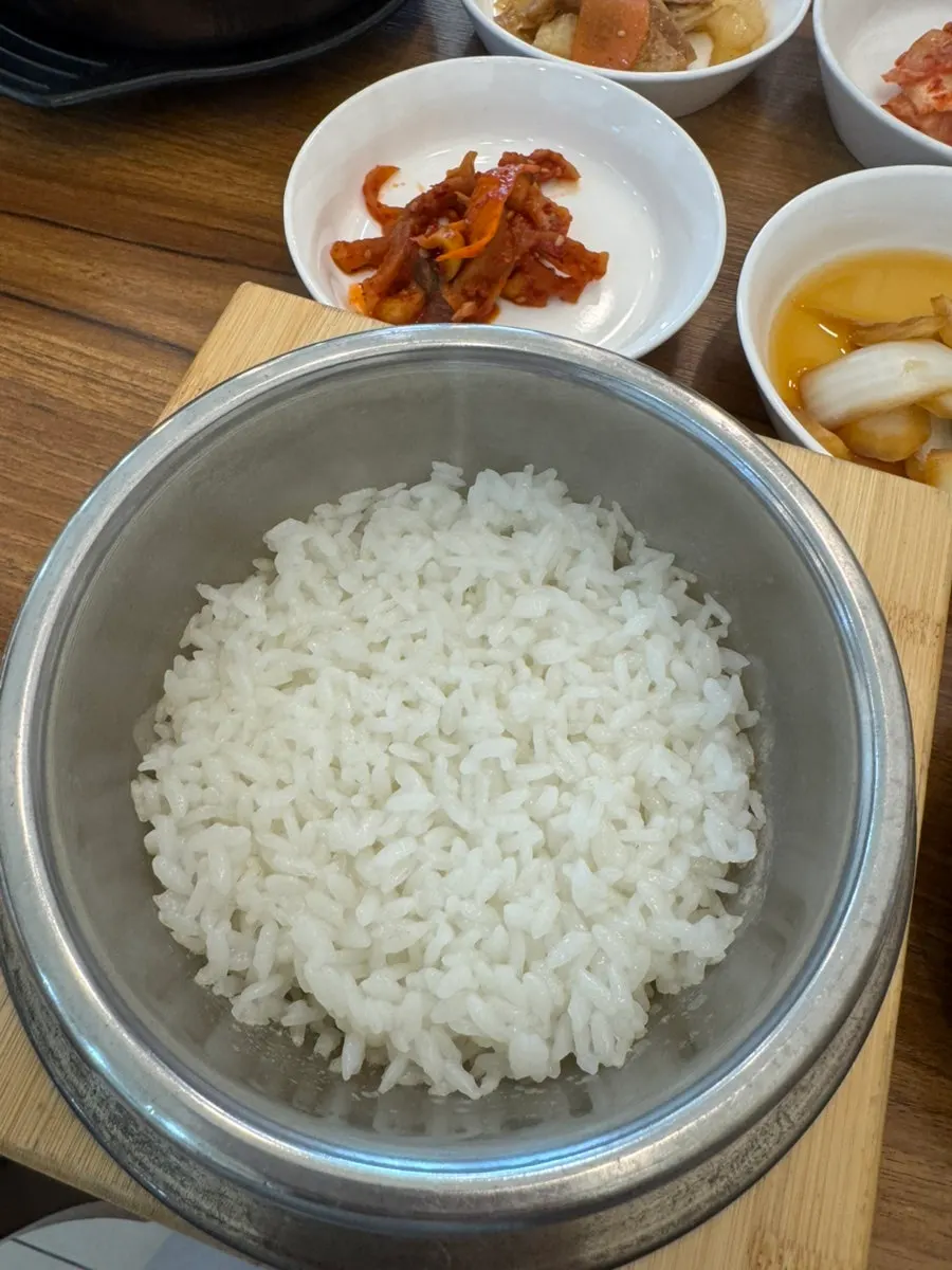 Flaked grilled tilefish meat next to stone pot rice