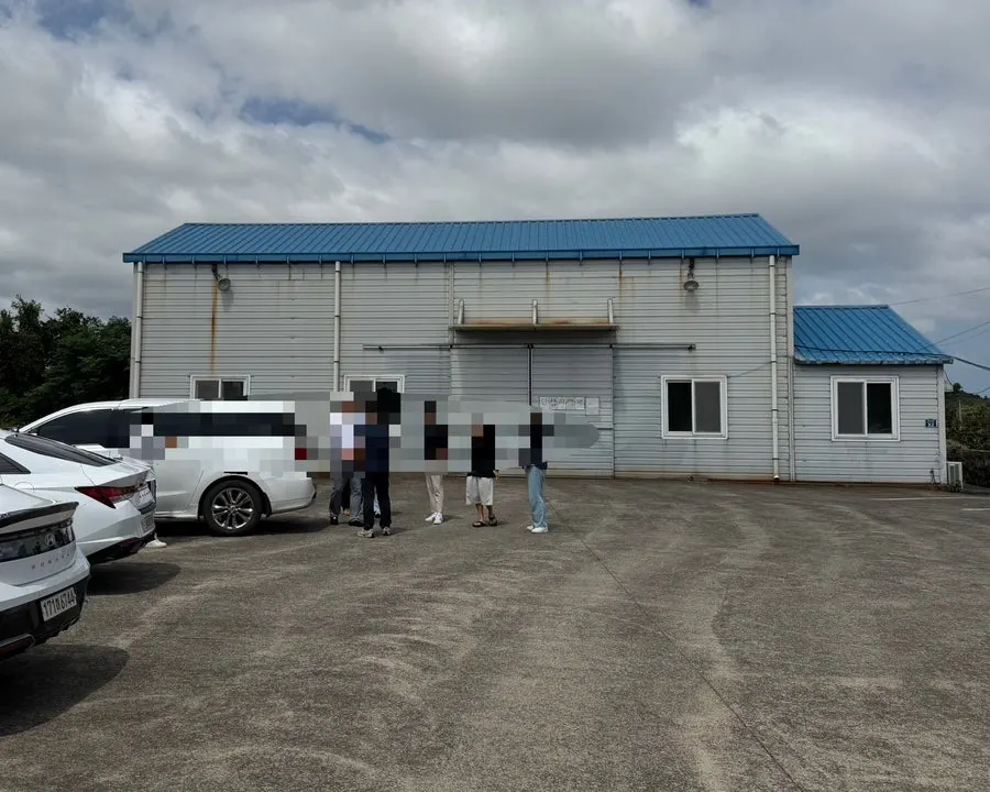 Open parking lot in front of the blue-roofed warehouse