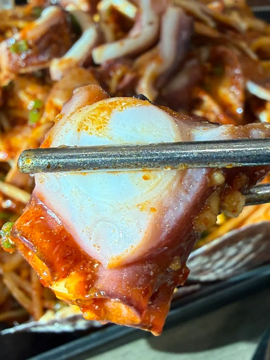 Chopsticks picking up an octopus leg
