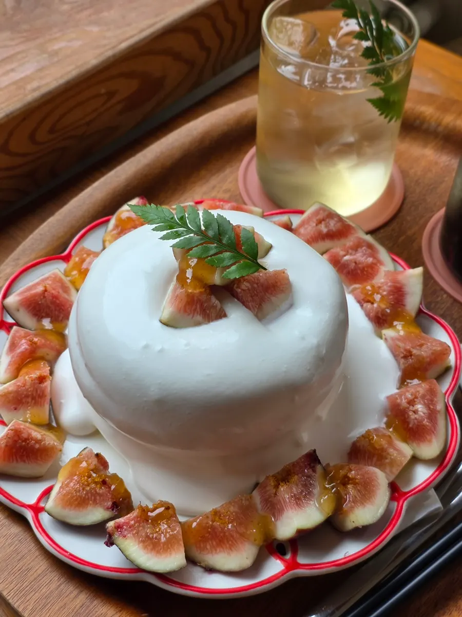 Two-layer fig soufflé surrounded by whipped cream and in-season figs