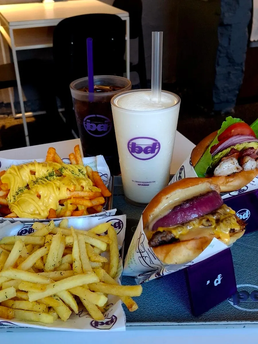 Table spread of burgers and sides ordered at bd Burger Seongsu