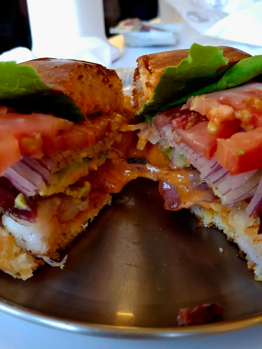 A bite taken out of the Grilled Shrimp Avocado burger