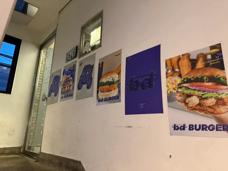 계단 벽면에 붙은 bd버거 포스터