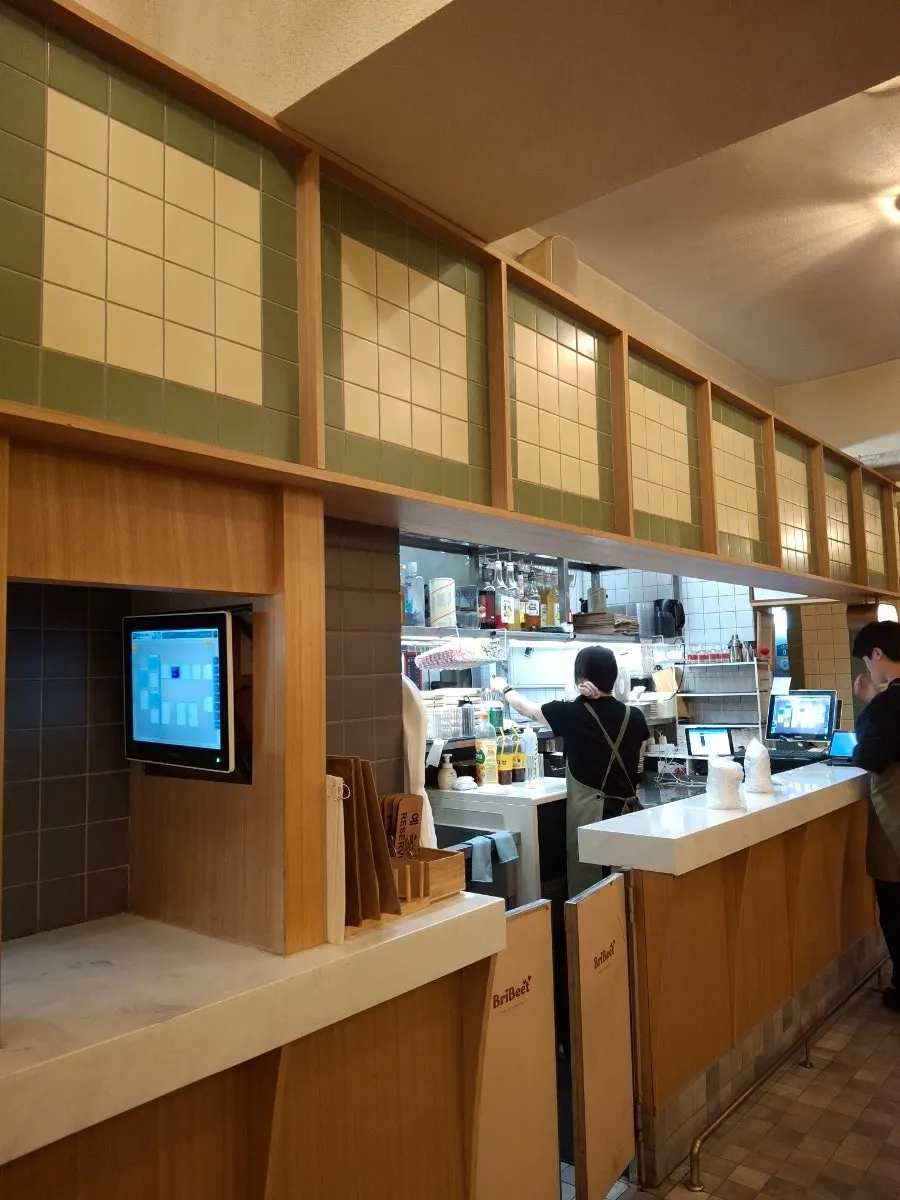 Interior of Brivite Seongsu with green tiles and wood tones