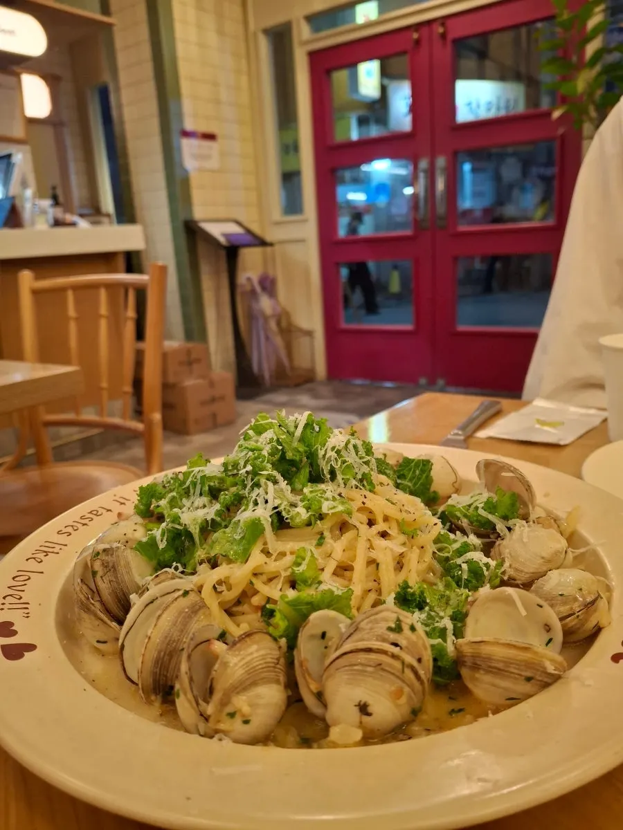 A plate of spicy vongole oil pasta topped with clams