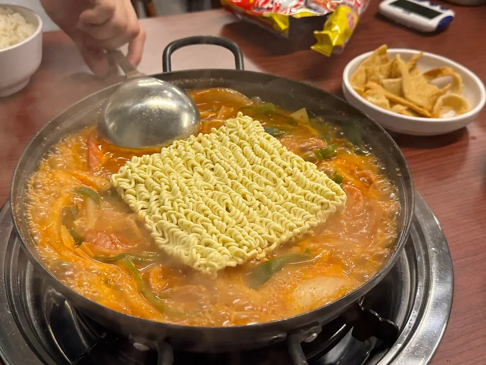 Ramen noodle add-on dropped into the boiling stew