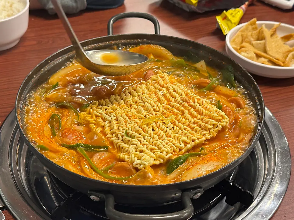 Ramen sari being cooked by ladling broth over it