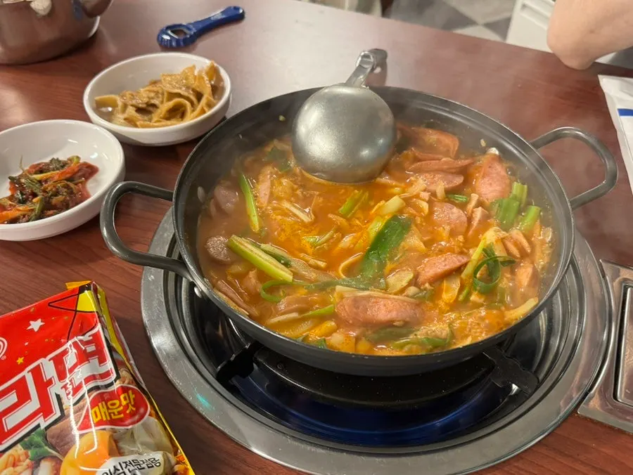Budae jjigae broth and ham simmering