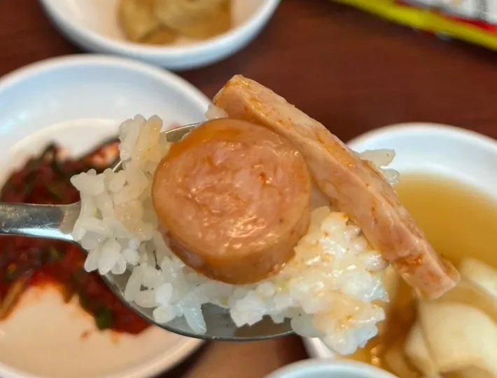 A spoonful of budae jjigae eaten with rice
