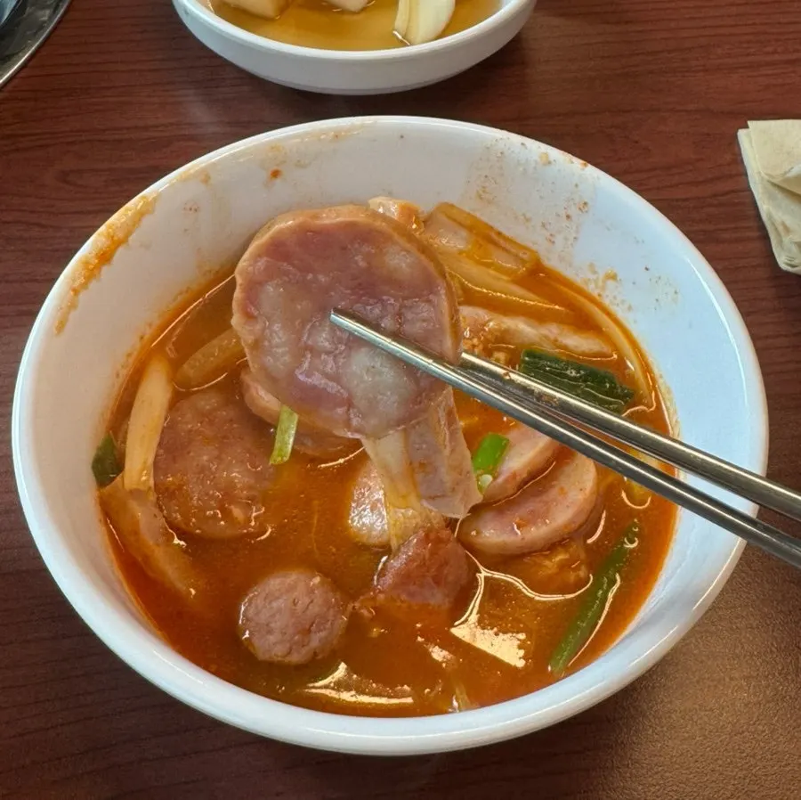 Budae jjigae sosej yang dicedok ke mangkuk