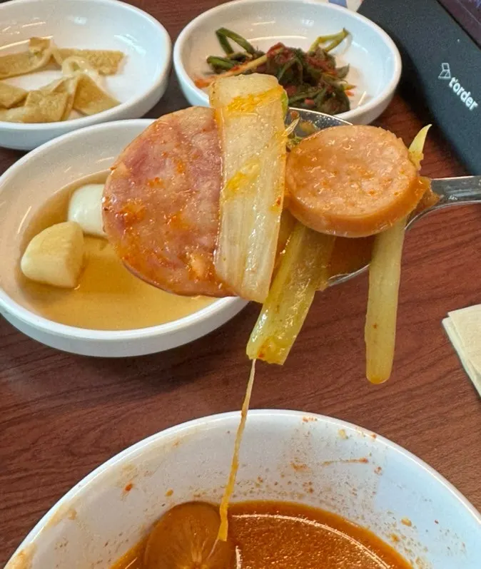 A bowl of budae jjigae full of sausage