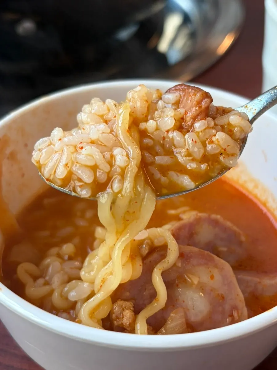 Rich budae jjigae broth full of ham and sausages