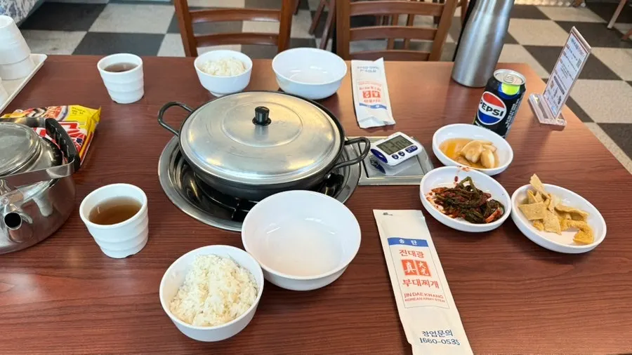 Budae jjigae side dishes including green onion kimchi