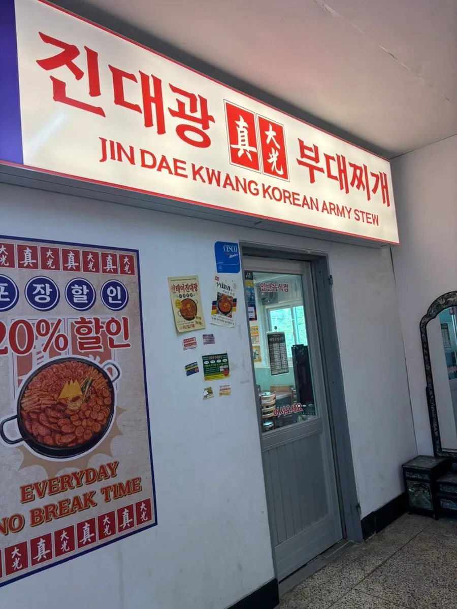 Budae jjigae standing sign and directions to the second-floor restaurant