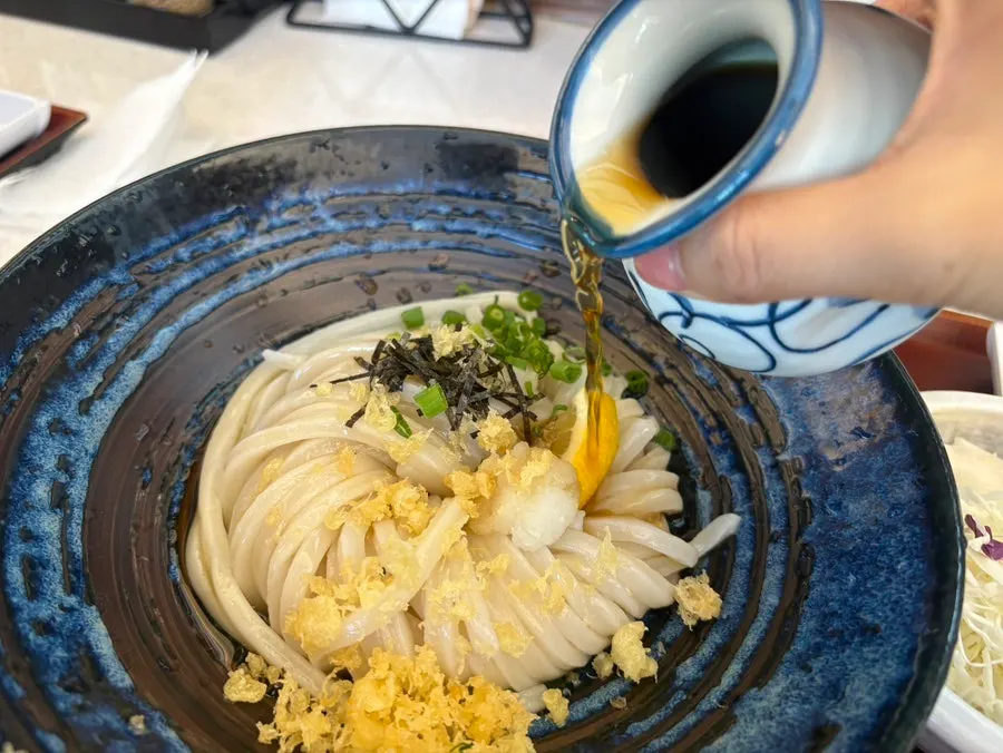 A dish of radish, scallion, and tempura bits toppings
