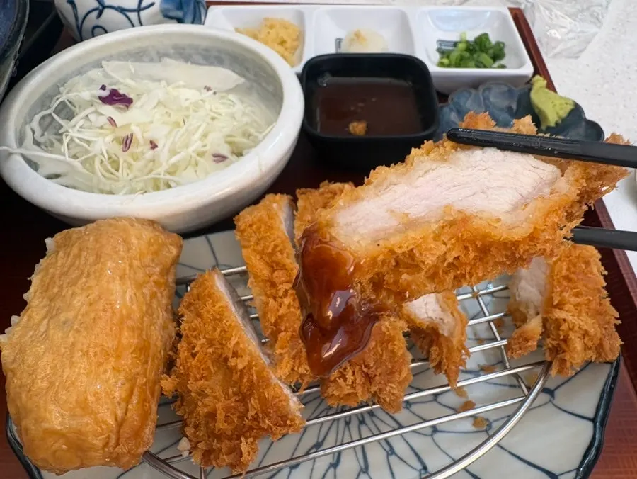 A piece of tonkatsu dipped in sesame-topped sauce