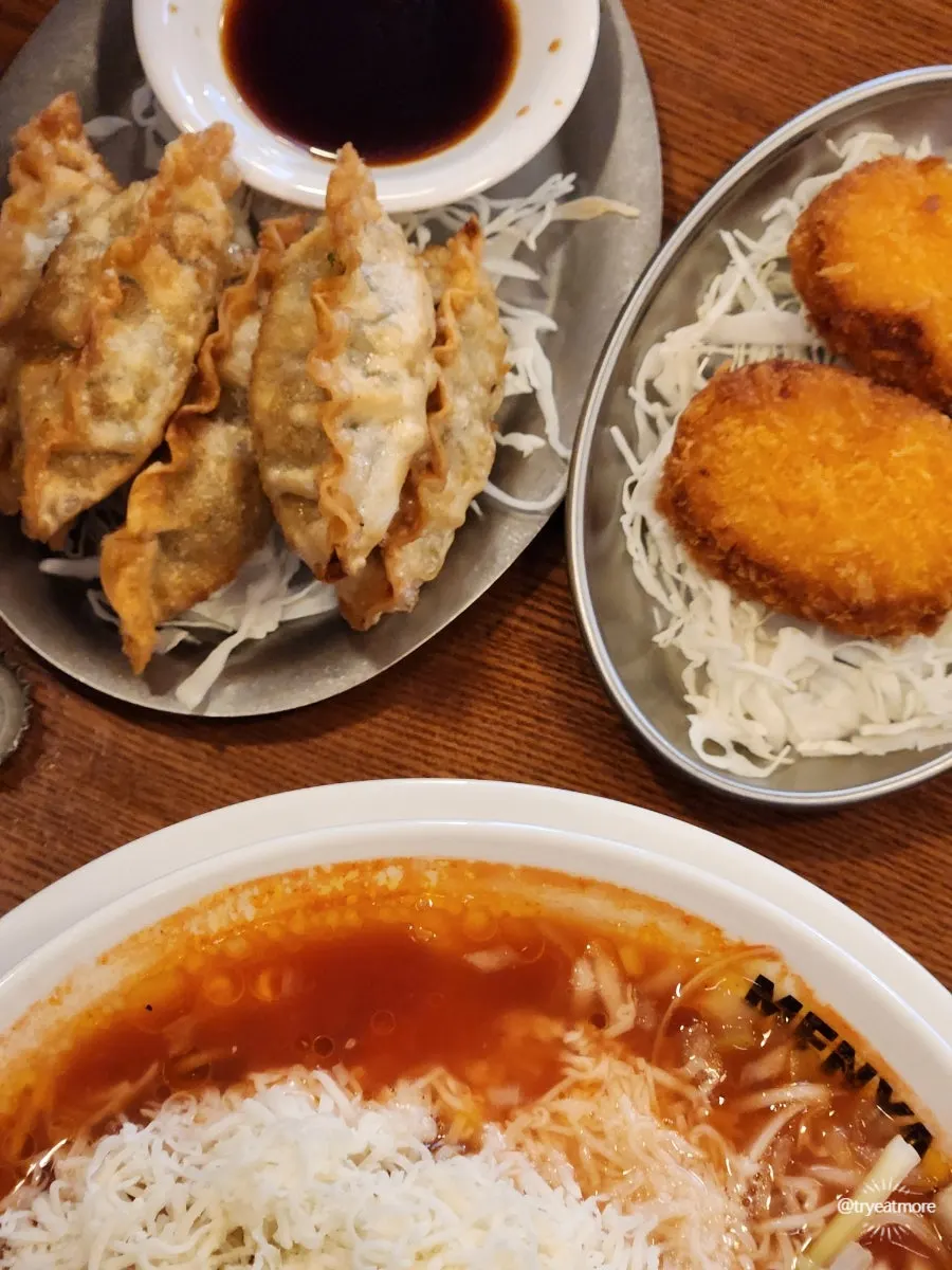 Table spread of tomato ramen and side dishes