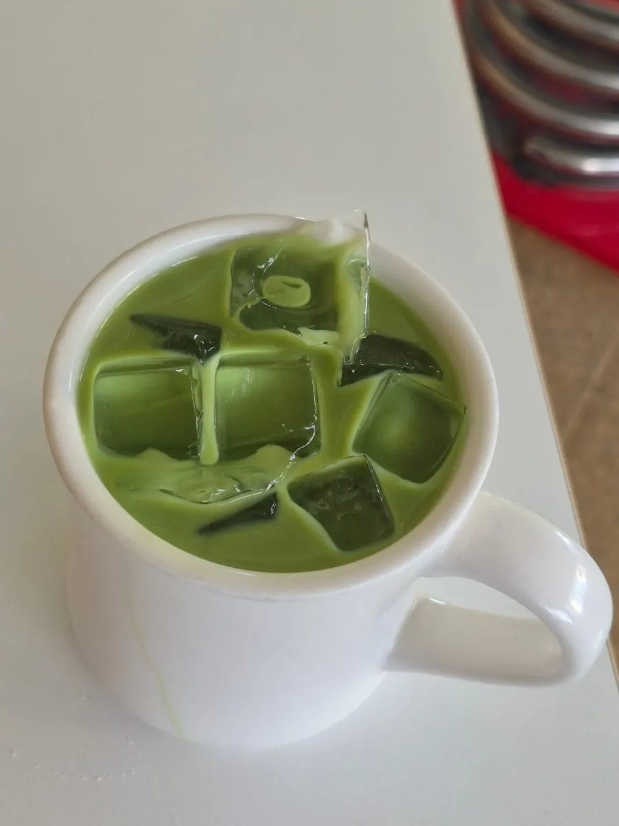Iced matcha latte served alongside dessert