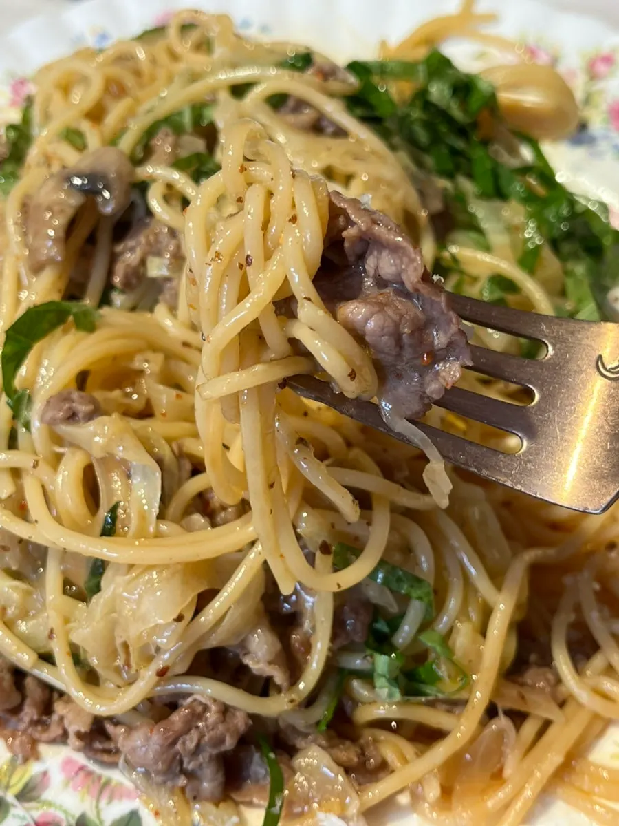 Beef brisket perilla pasta being mixed with sauce and toppings