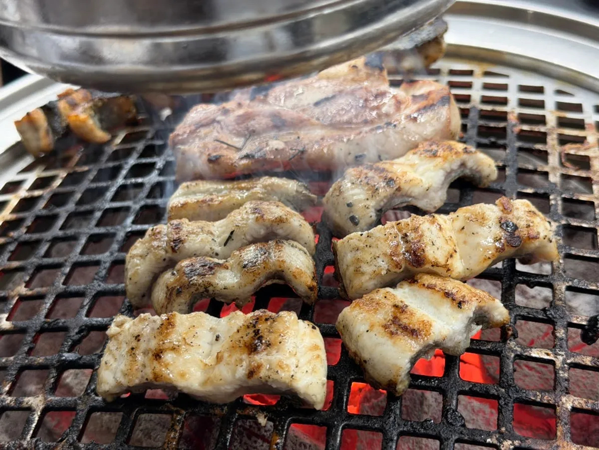 Freshwater eel and pork belly grilling over charcoal