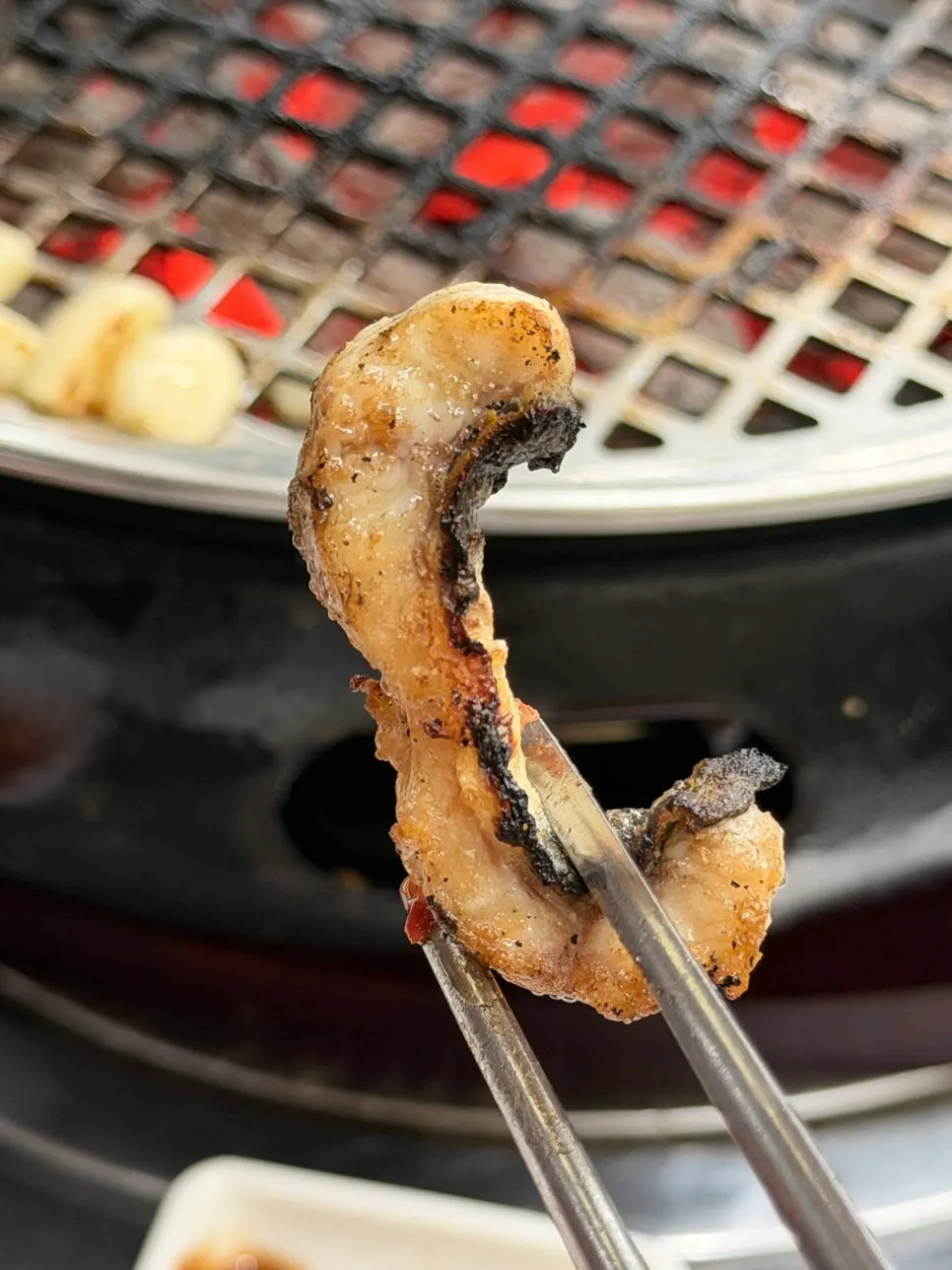 A tray of eel cooking over charcoal