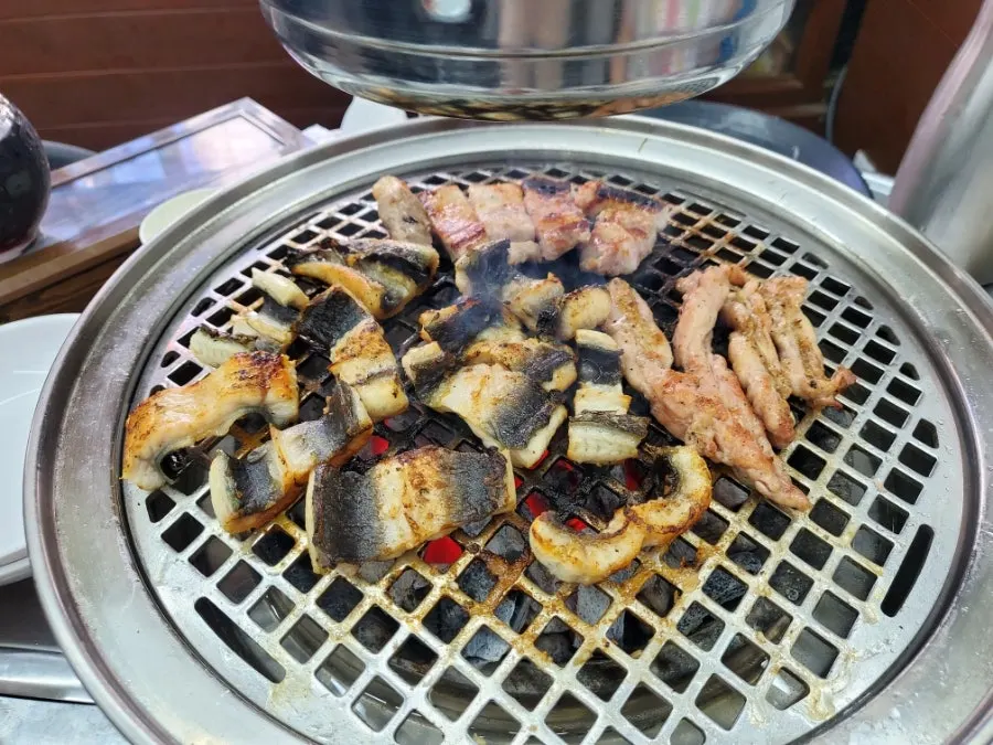 Golden-grilled eel next to a glass of bokbunja wine