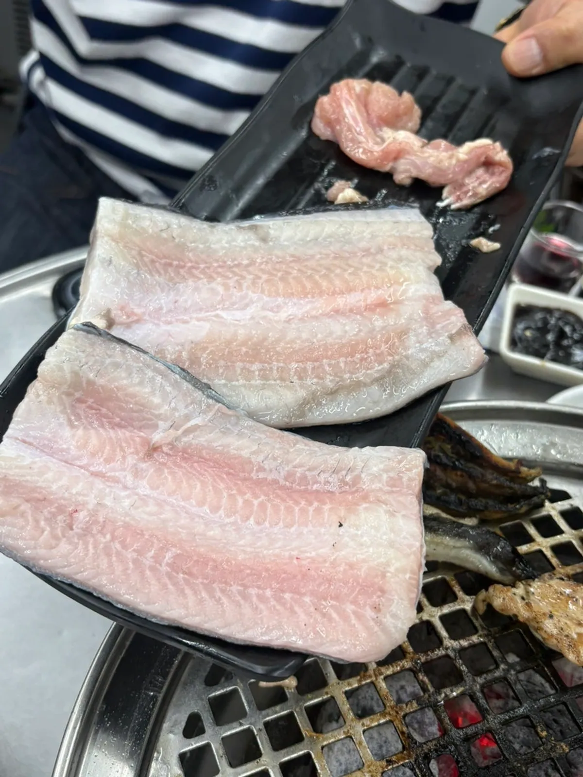 A piece of grilled eel topped with ginger strips