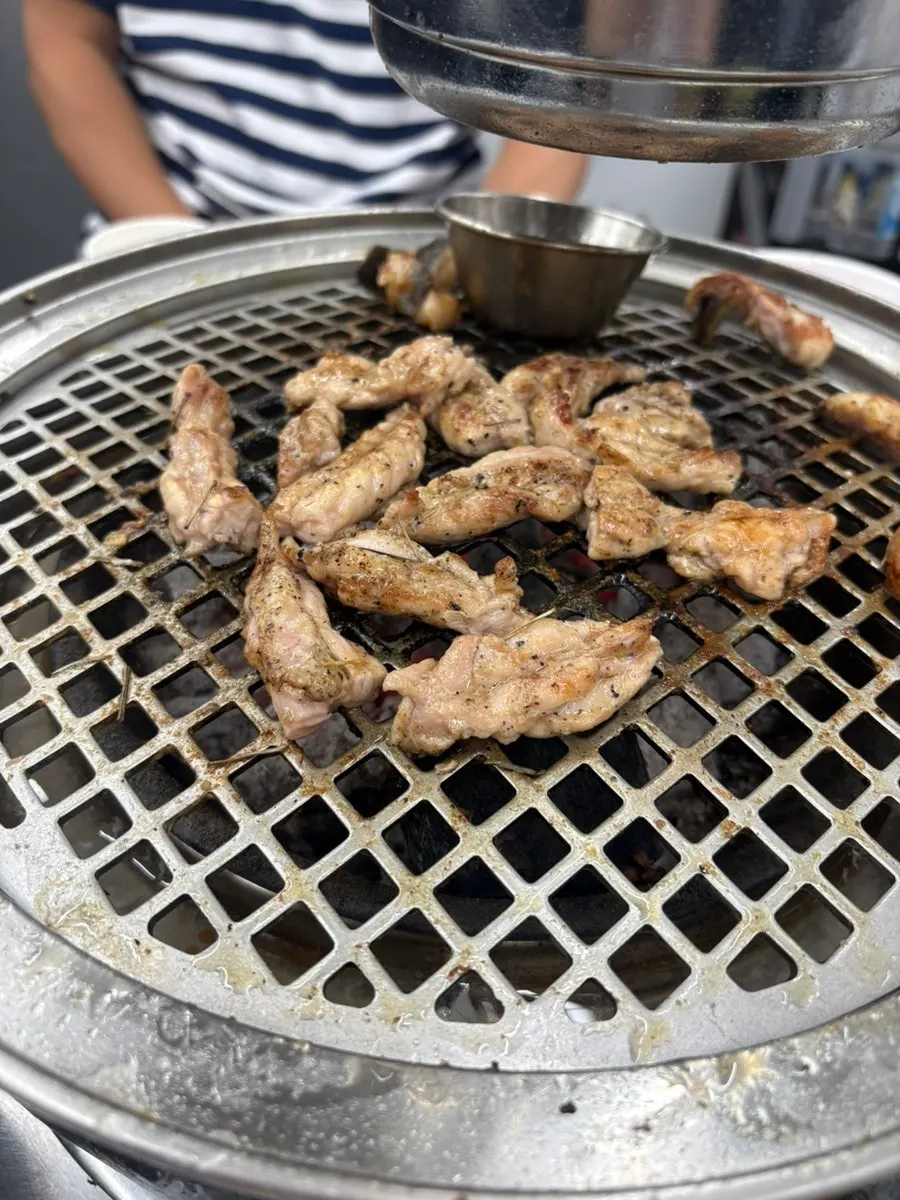 Pork belly and chicken neck cooking on the grill