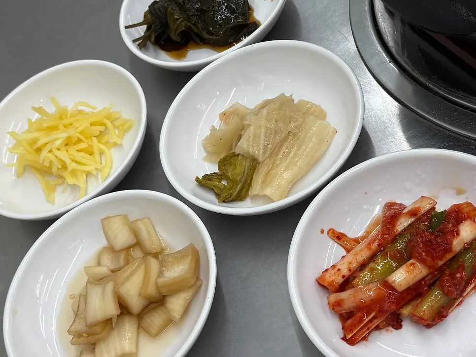 숯불이 달궈지는 테이블과 기본 반찬 세팅