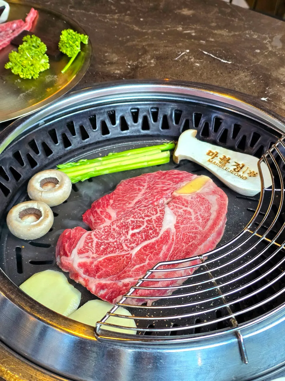 Staff grilling service with beef placed on the grill