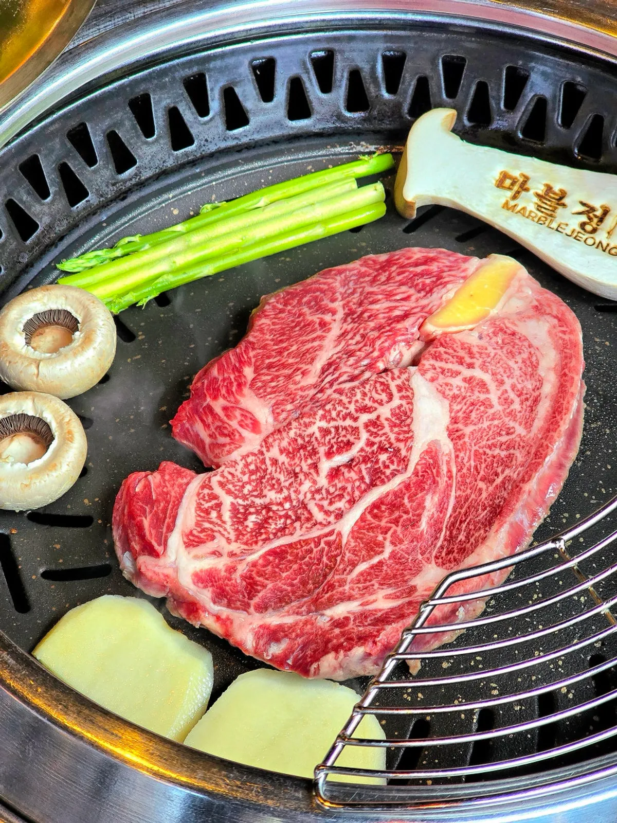 Premium beef sirloin and garnish cooking on the grill