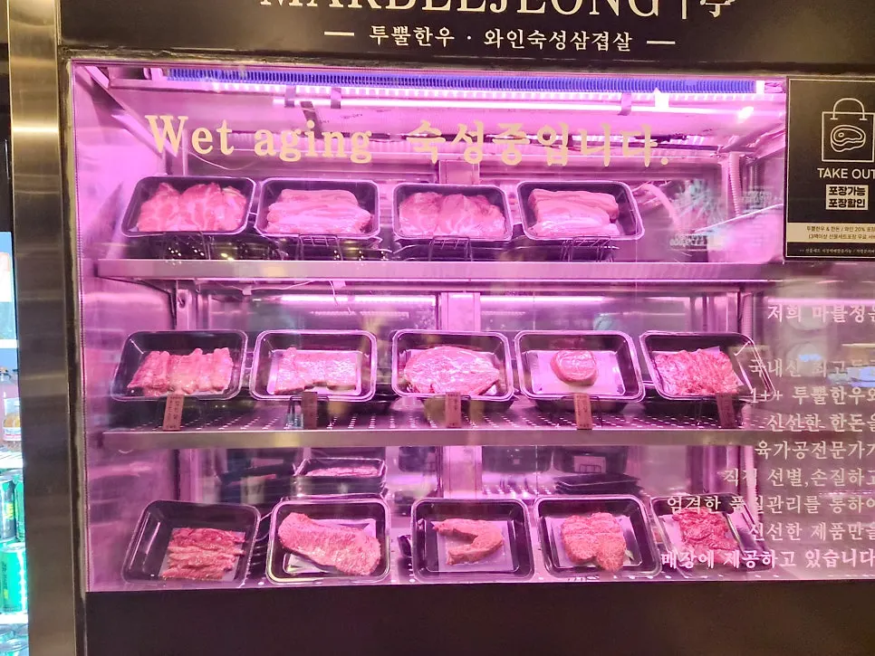 와인잔이 걸린 바 테이블과 골드 프레임 체어 좌석