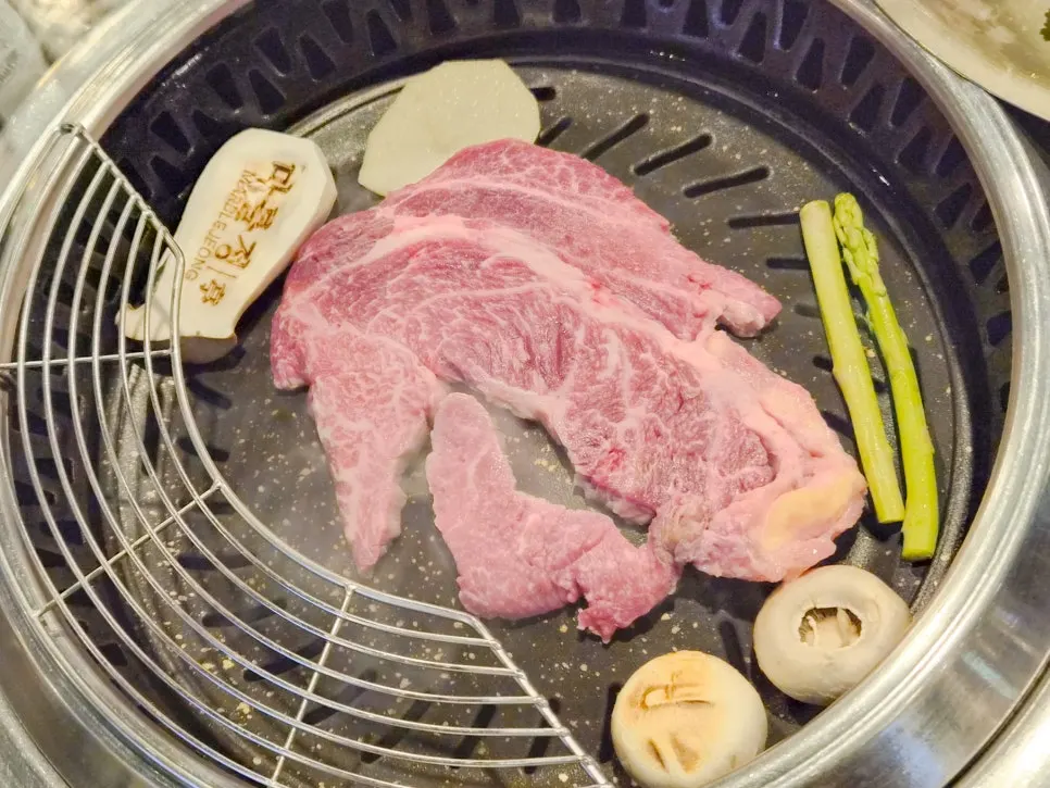 직원이 버섯·아스파라거스와 함께 굽는 투뿔한우 등심