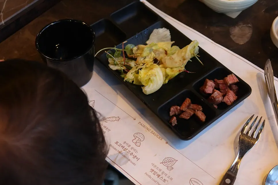 Korean beef sirloin grilling alongside garnishes