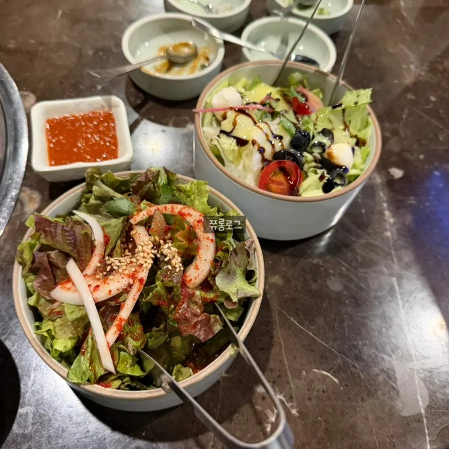 Basic side dishes at Marblejeong, including mustard leaf kimchi and mountain leek
