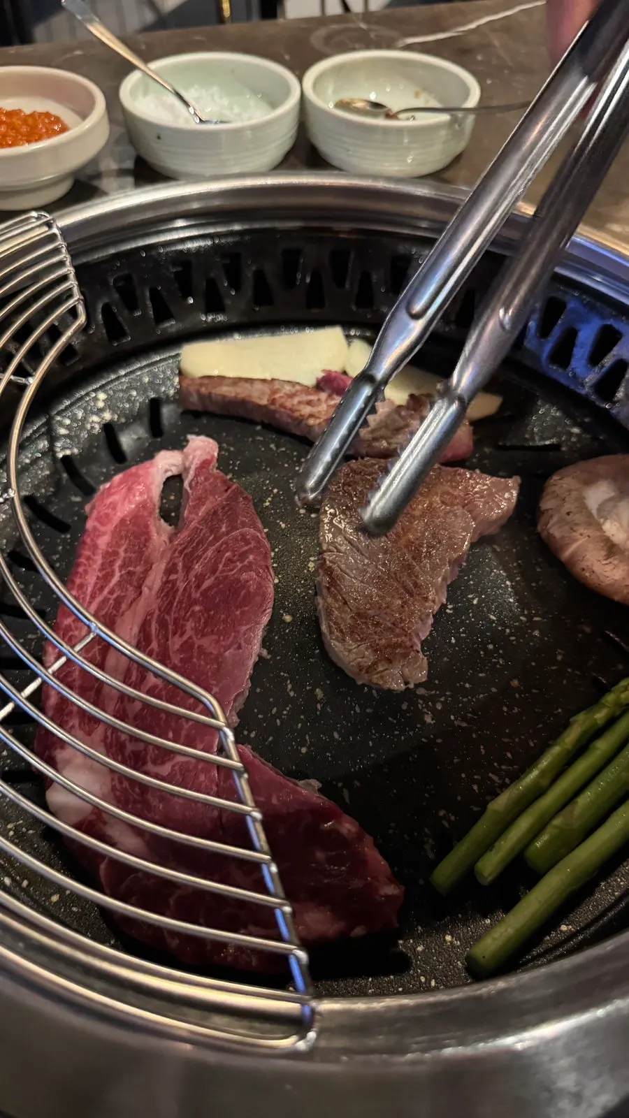 Staff member grilling Korean beef as part of the grilling service