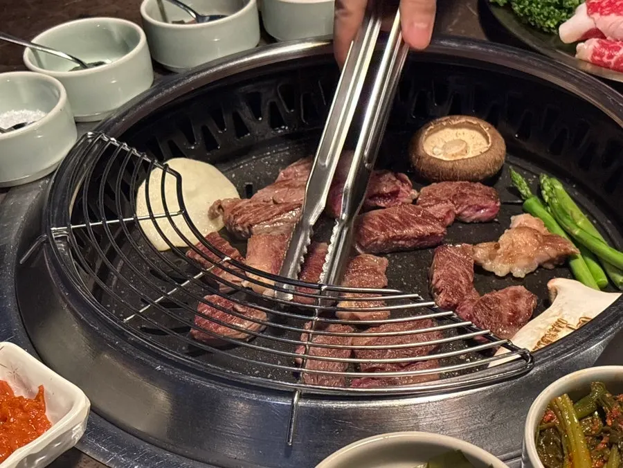 Staff member grilling Korean beef sirloin