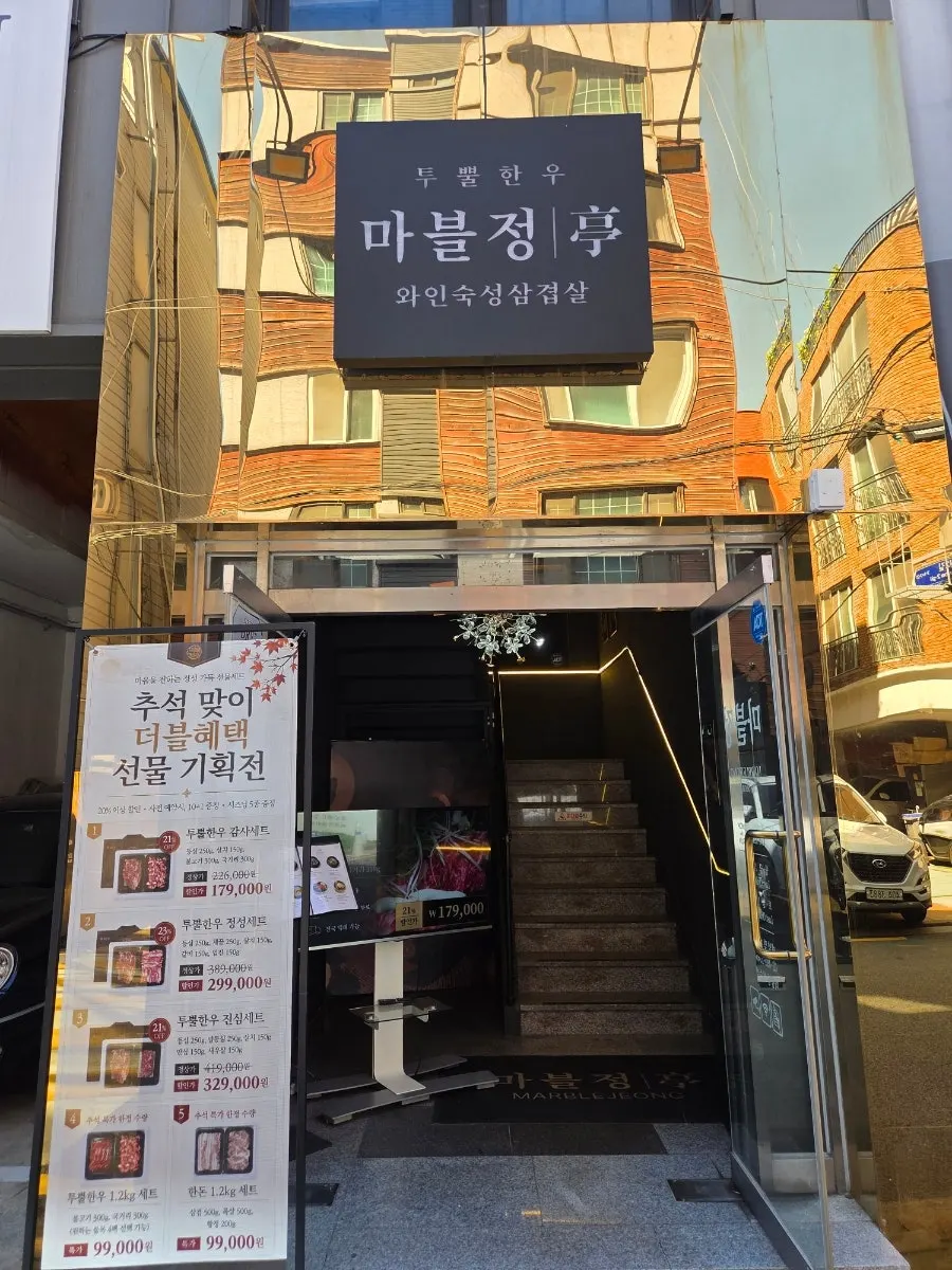 Marblejeong's building entrance with signage pointing to the 2nd floor