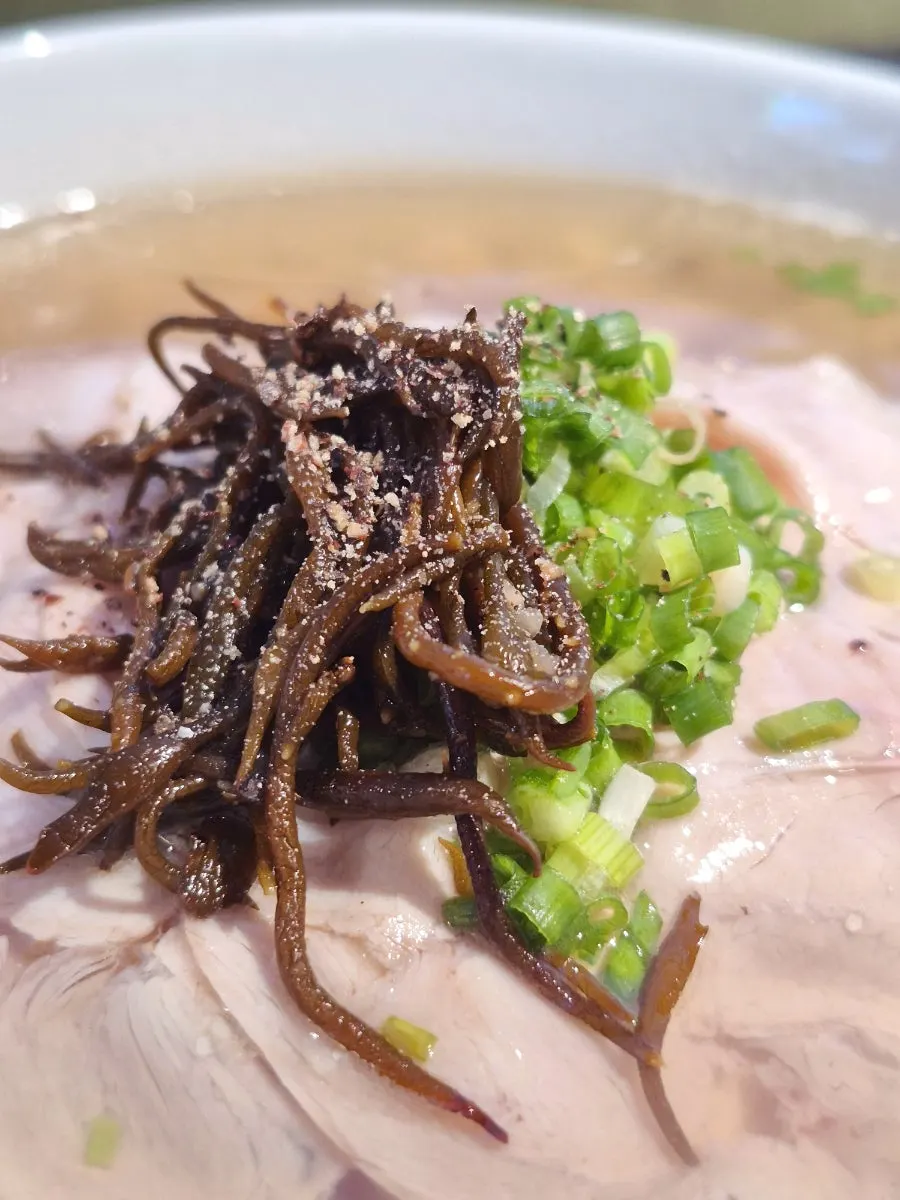 Three minari toat wang mandu on a plate as large as a soup bowl