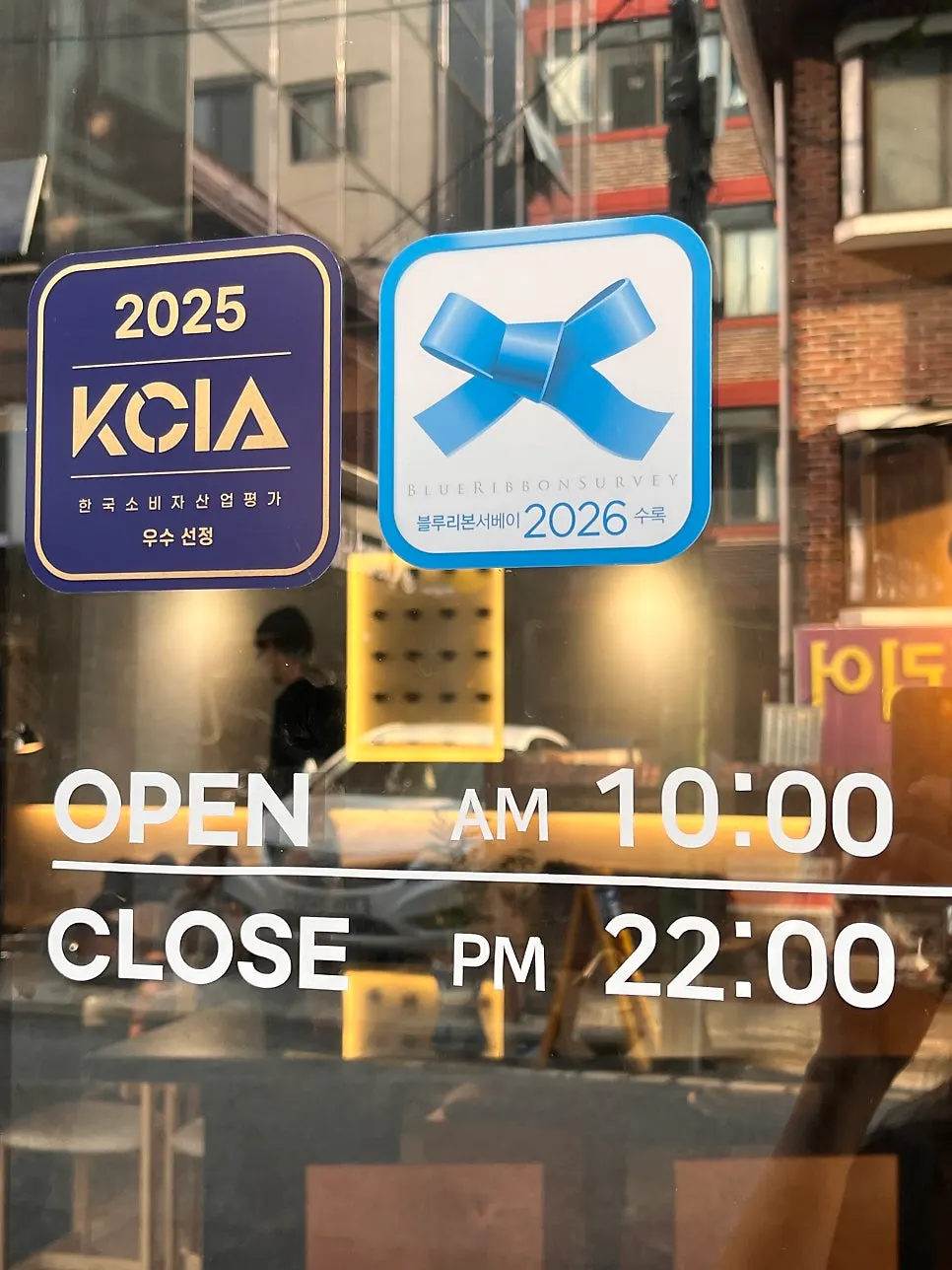 Entrance door showing Iridescent's business hours