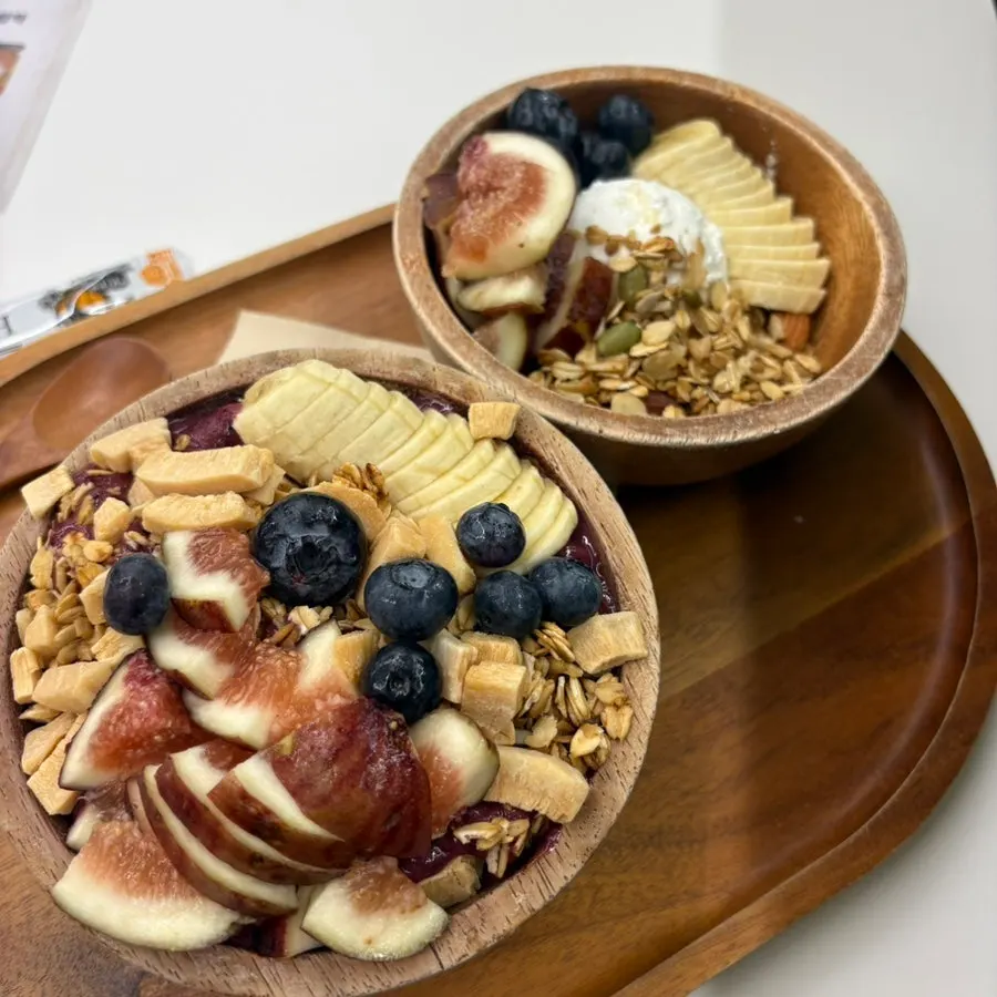 Greek yogurt and acai bowl served on a wood tray