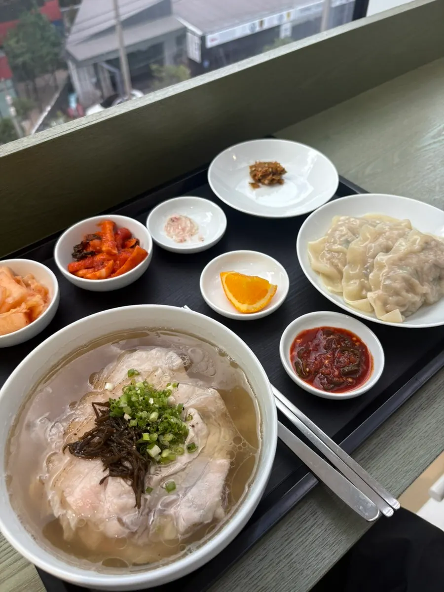 A full spread of the clear gomtang set and minari tot giant mandu