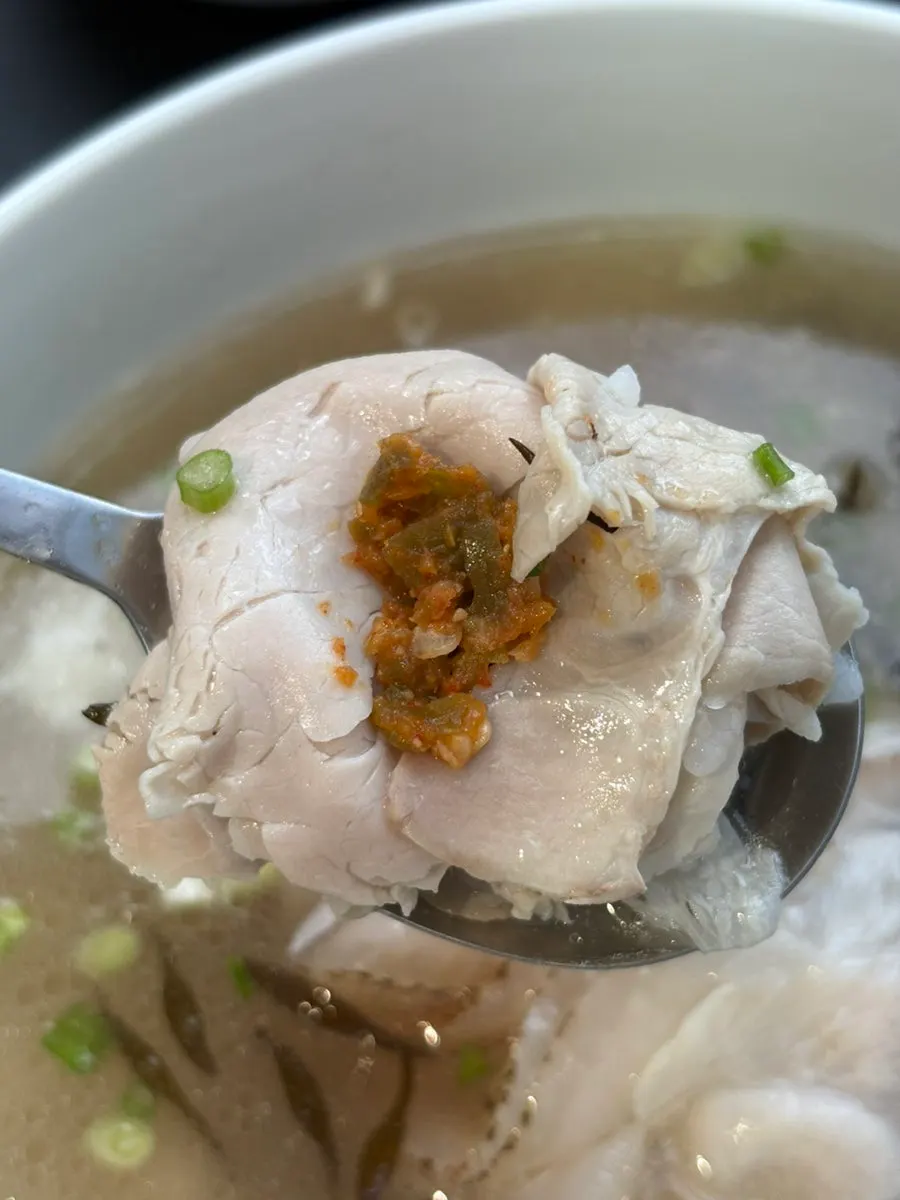 A spoonful of the gomtang broth lifted up