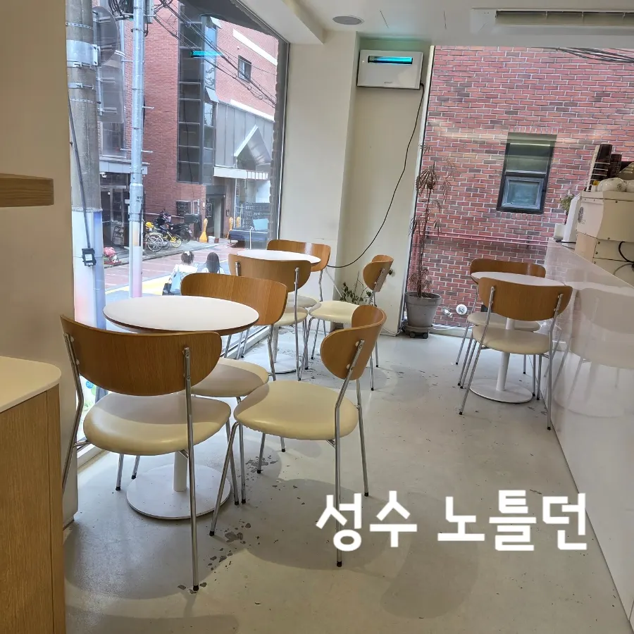 화이트톤 노틀던 매장 내부와 통창 테이블