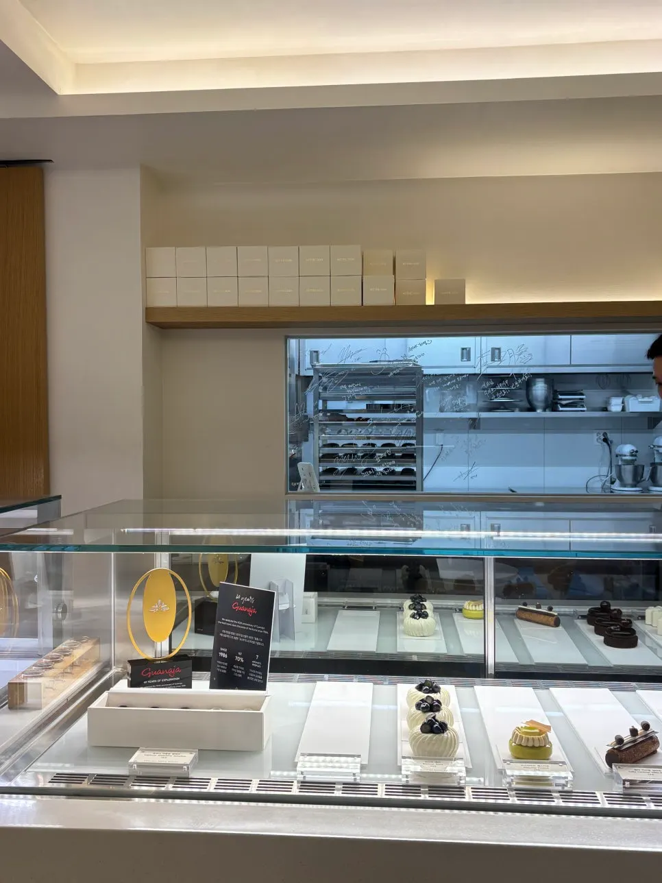 Vitrina de postres con la cocina abierta al fondo