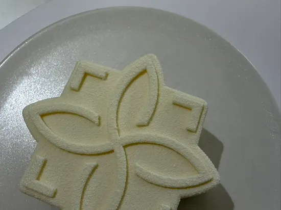 White ribbon-shaped Notldun Signature Blanc cake