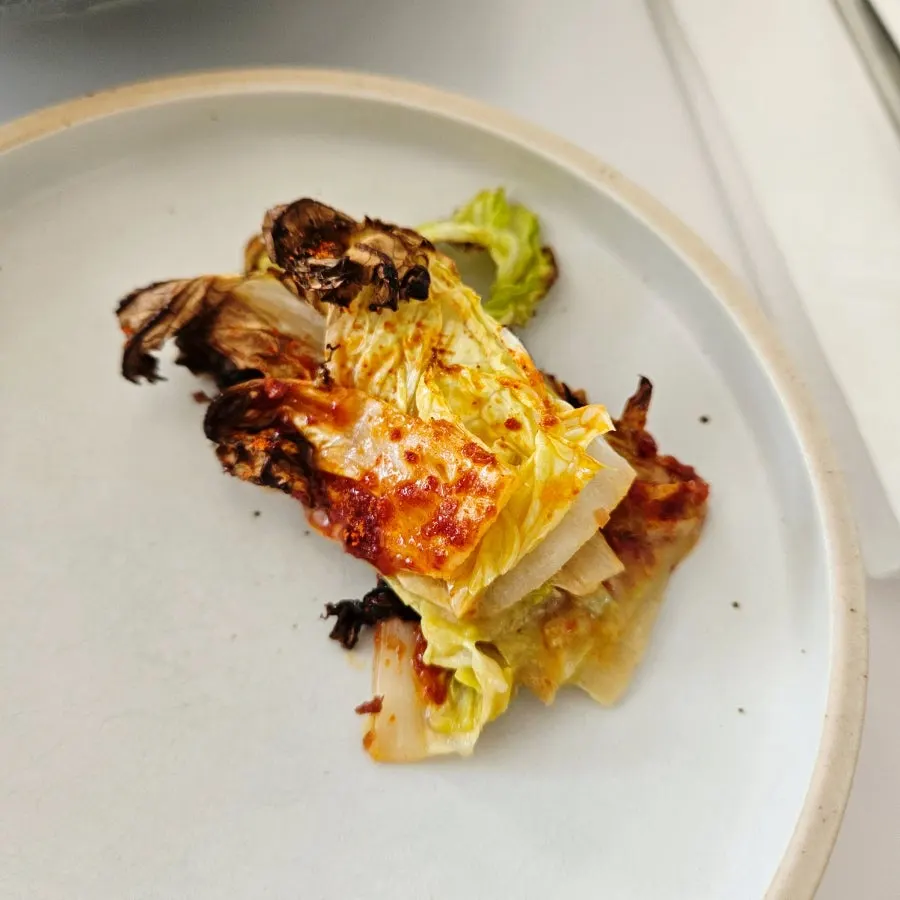 A bite of grilled napa cabbage coated in Chinese-style sauce