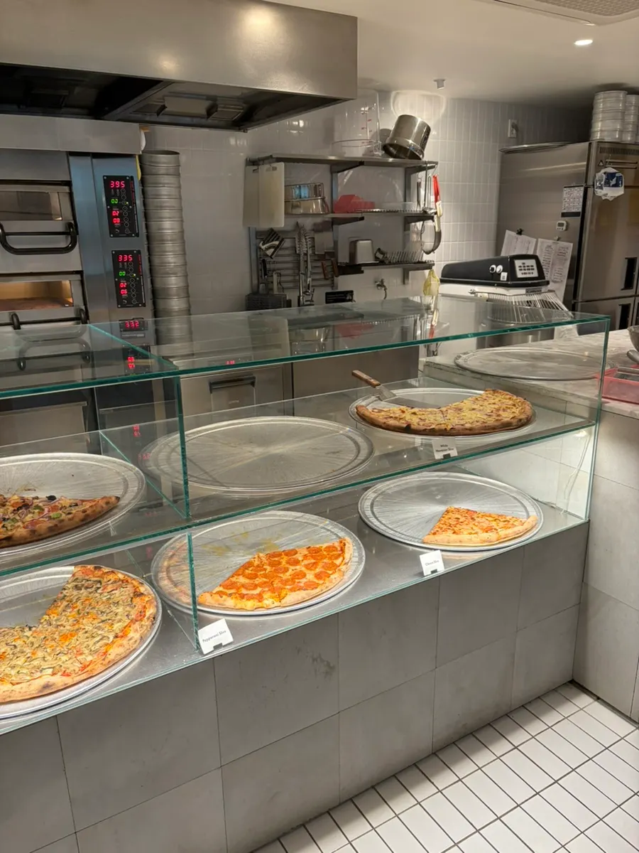 Counter with various types of slice pizza laid out