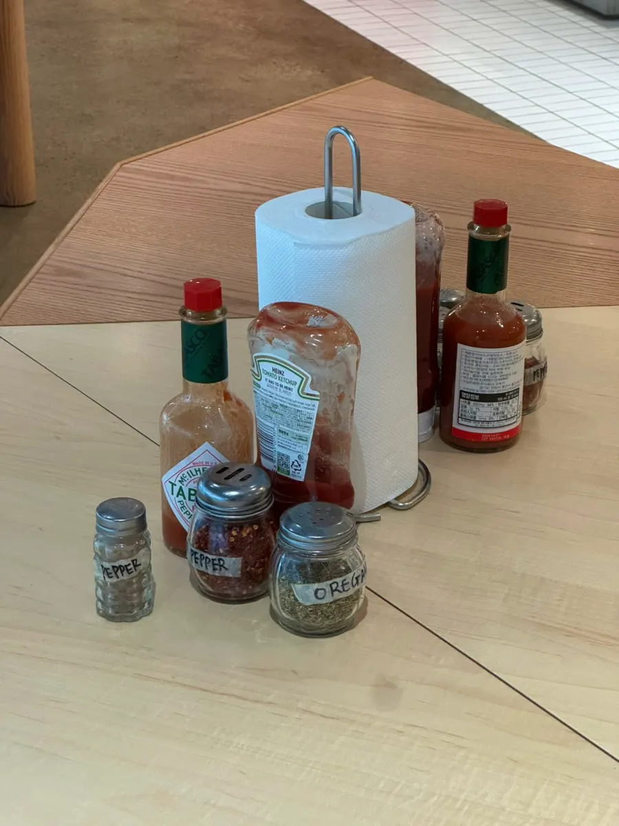 Red pepper flakes, Tabasco, and ketchup on the table