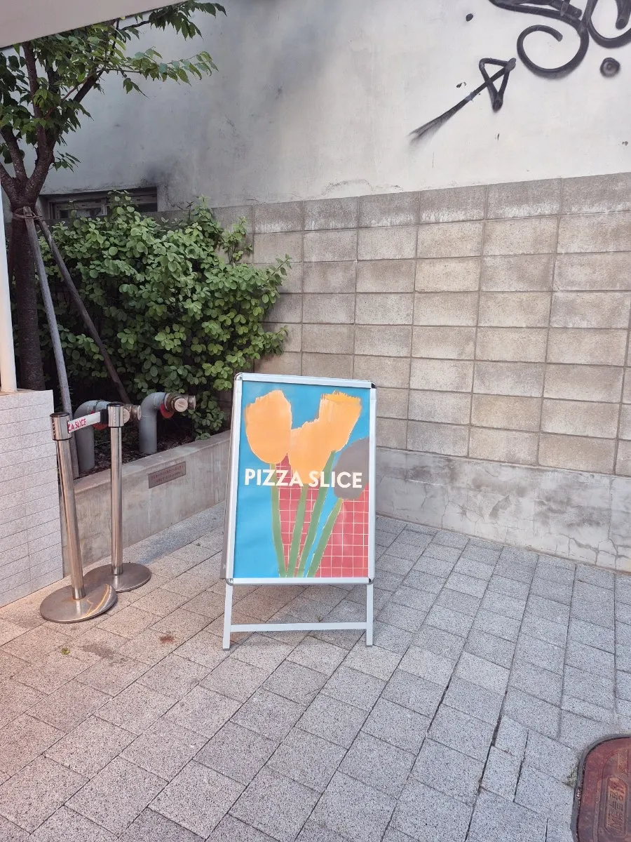 Vertical photo of the Pizza Slice Seoul entrance near Seongsu Station